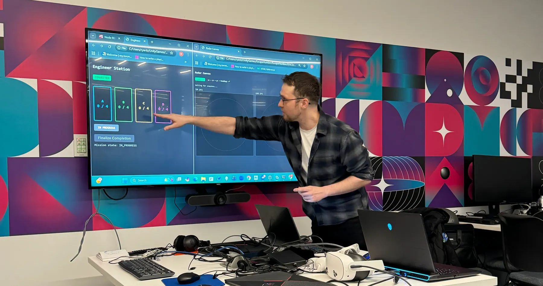 Konrad Karczewski presenting a virtual-reality escape-room interface on a large display in Toronto Metropolitan University’s Master of Digital Media studio.