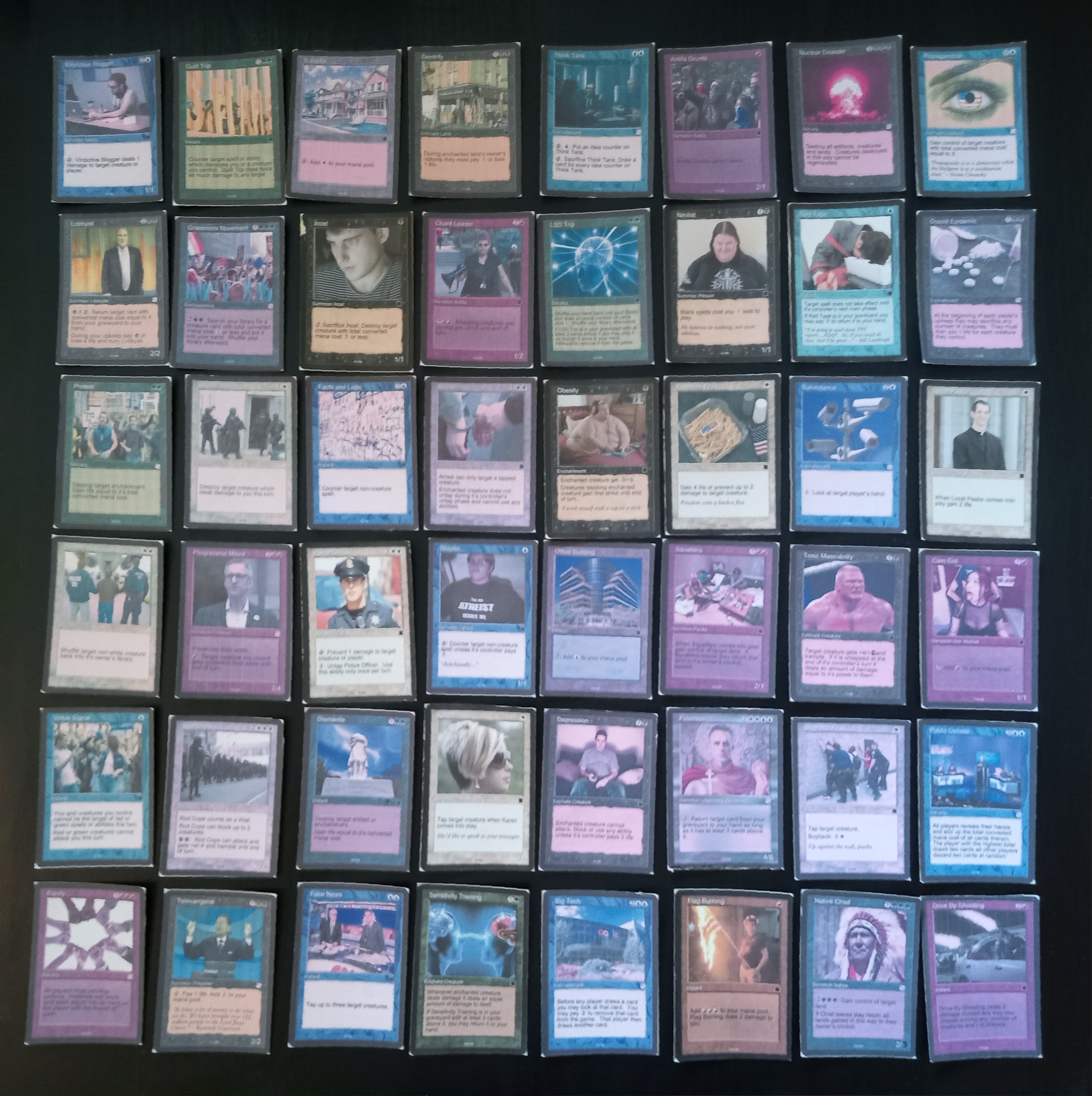 Rows of worn handmade prototype cards arranged on a dark surface.